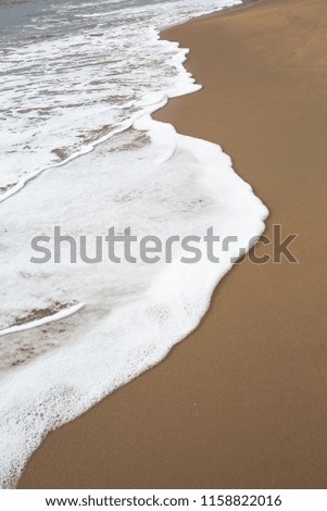 White foam wave on smooth beach