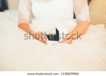 Elegant bride holding wedding rings.