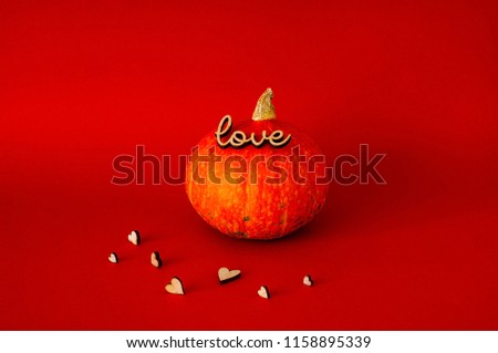 Symbol of HALLOWEEN is Orange pumpkin using the stamp "love", isolated on red background,copy space, closeup,