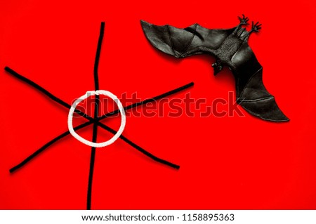 Symbol of HALLOWEEN is bat and black spiderweb on red background,copy space, closeup,
