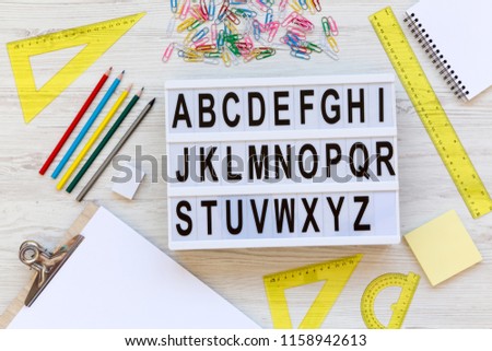Back to school concept. Letters from A to Z. English alphabet on modern board over white wooden surface, top view. From above, flat lay, overhead.