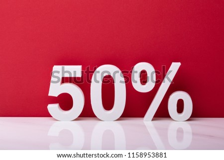 White Fifty Percent Sale Sign In Front Of Red Wall