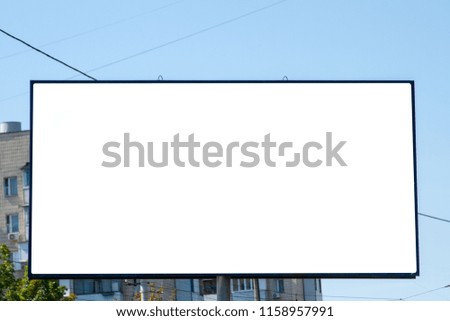 White billboard on the background of a residential high-rise building. Outdoor advertising in a residential area. Empty white canvas bigboard with space for text. Big billboard in the city landscape.