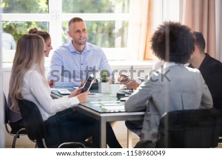 Group Of Businesspeople Sitting In Office During Business Meeting