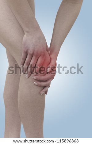 Acute pain in a woman  knee. Female holding hand to spot of knee-aches. Concept photo with Color Enhanced skin with read spot indicating location of the pain.