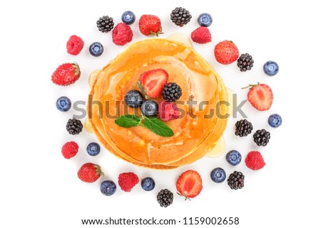 Pancakes stack with different berries isolated on white background. Top view. Flat lay Royalty-Free Stock Photo #1159002658