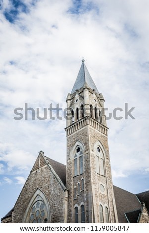 Steeple of classic church against cloudy sky