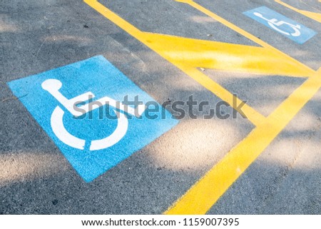 Image of the signs of places for people with disabilities in the parking lot for cars. Handicapped symbol on parking space 