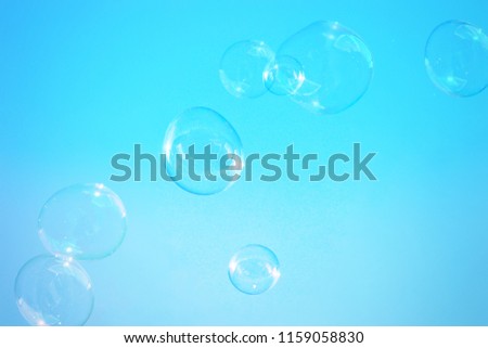 A digitally enhanced and artistically filtered photograph of a group of bubbles floating through the air in front of a colour gradient background. 