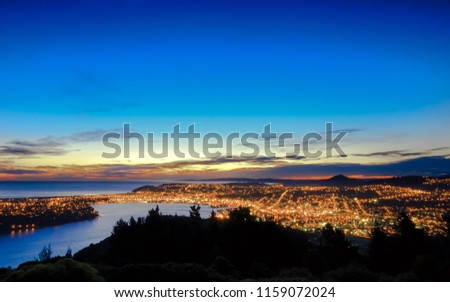 Hill top view of Dunedin City. From the top, one can enjoy beautiful city lights, sunset and colorful sky. Dunedin is a popular tourist destination in South Island of New Zealand. Royalty-Free Stock Photo #1159072024