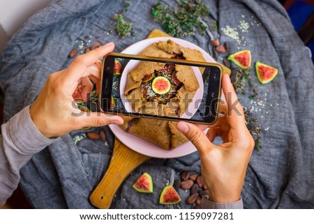 Phone food photography. Smartphone photo of food during lunch or dinner. Blogging and social media food photo on mobile camera. Trendy food shot. Vegan sweet figs tart dessert Royalty-Free Stock Photo #1159097281