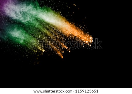 Multi color powder explosion isolated on black background.Colored dust splash on dark background.