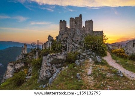 Rocca Calascio (Italy) - The ruins of an old medieval village with castle and church, over 1400 meters above sea level on the Apennine mountains in the heart of Abruzzo, at sunset. Royalty-Free Stock Photo #1159132795