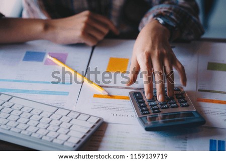 Businesswoman analyzing investment charts with calculator for financial data analyzing counting. Business financial analysis and strategy concept. Royalty-Free Stock Photo #1159139719