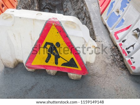 Road repair sign, man at work. Selective focus.
