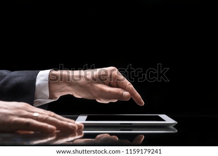 Male person working on digital tablet