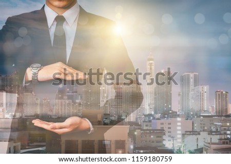 Businessman withprotective gesture The double exposure image of the business man standing back during sunrise overlay with cityscape image. The concept of modern life, business, city life and internet