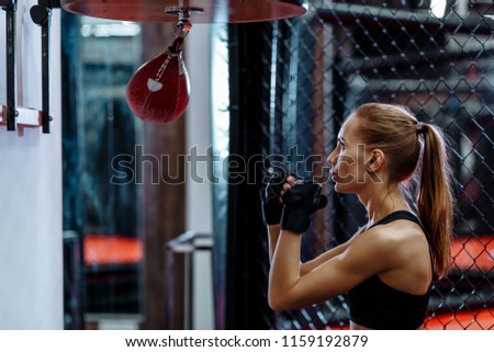 Young blond women boxing, hitting small boxing bag