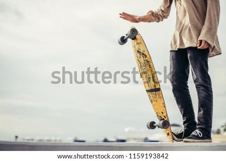 Close up of man foots riding longboard in park