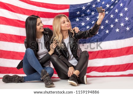 happy young women are posing to their cell phone. close up full length photo. teen concept