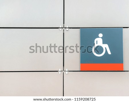 Handicapped sign, detail of an information signal, handicapped sign on a gray background