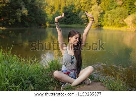 cheerful girl with raised arms and closed eyes enjoying her summer holidays. happiness and rejoice concept. full length photo