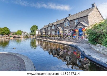 Cottages reflecting in the water of  Brecon Canal basin  in Brecon town, Brecon Beacons National Park, Wales, UK Royalty-Free Stock Photo #1159247314