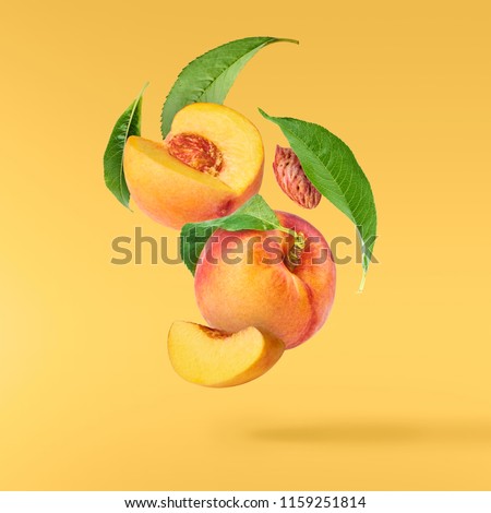 Flying fresh ripe peach with green leaves isolated on yellow background. Concept of food levitation, high resolution image Royalty-Free Stock Photo #1159251814
