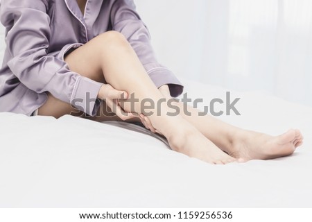 women lag pain on bed in bed room in the morning.color tone Royalty-Free Stock Photo #1159256536