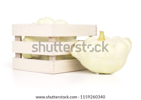 Group of two whole summer white pattypan squash with wooden crate isolated on white background