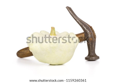 One whole summer white pattypan squash with a hammer isolated on white background