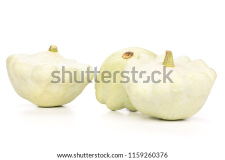 Group of three whole summer white pattypan squash isolated on white background