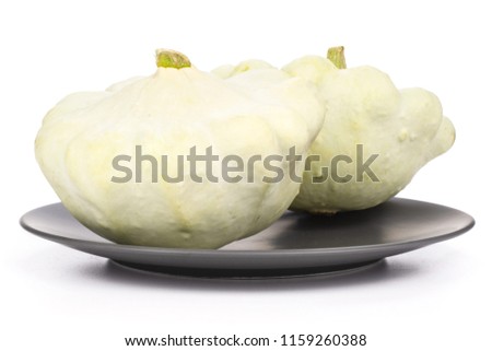Group of two whole summer white pattypan squash on grey ceramic plate isolated on white background