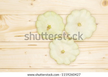 Set of three whole summer white pattypan squash flatlay on natural wood
