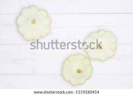 Group of three whole summer white pattypan squash flatlay on grey wood