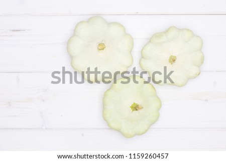 Set of three whole summer white pattypan squash flatlay on grey wood
