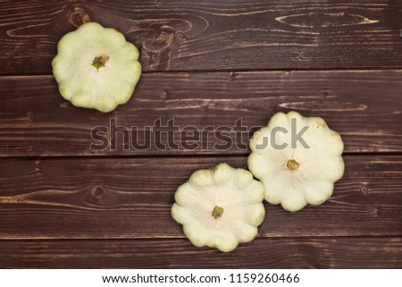 Group of three whole summer white pattypan squash flatlay on brown wood