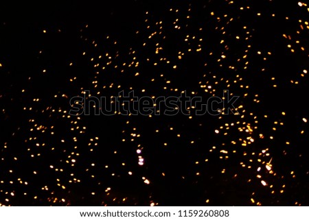 Abstract colored golden firework isolated on a black background with free space for text.  Concept of Christmas and New Year holidays. Bengal lights, glitter and sparks. Free space for text.