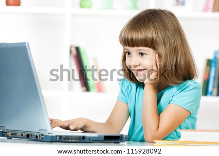 Cute little girl smiling and looking at laptop,Little girl using laptop Royalty-Free Stock Photo #115928092