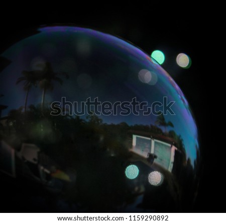 A close-up photograph of a digitally manipulated glossy soap bubble. 