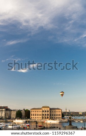 Vertical photo picture with copy space of blue sky white clouds: National Museum of Fine Arts (Nationalmuseum) building in centre with colorful hot air balloon view from Gamla Stan, Stockholm, Sweden
