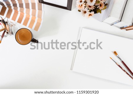 Top view office desk with designer table a Pantone, coffee and notebook paper sketch on white table artist workspace above view.