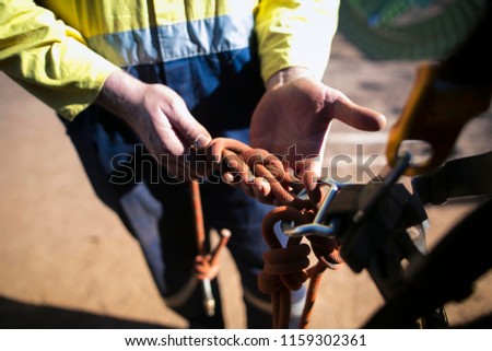 close up picture of rope access miner worker hand inspector commencing inspection figure of eight knot prior to use construction site Perth, Australia  