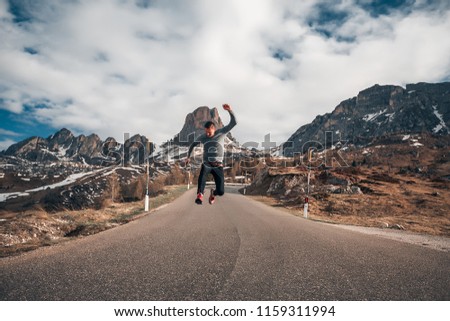 Handsome man amazing mountains background, sport, jumping, resting in a mountains, hiking, travel time, happy, road, nature, sporty guy, alps, dolomites, attractive, belt, sneakers, jeans