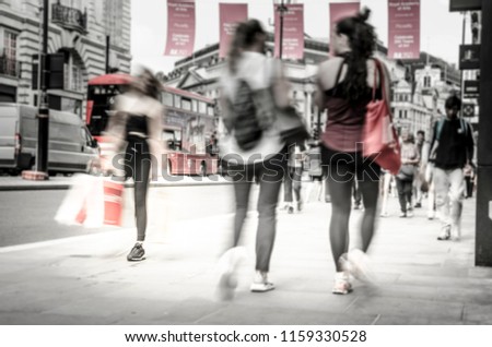 Abstract anonymous shoppers on busy shopping street, desaturated and motion blurred. 