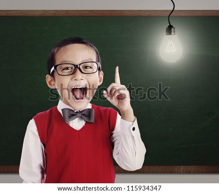 Asian genius student with light bulb shot in a classroom Royalty-Free Stock Photo #115934347