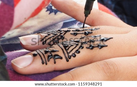 Henna tattoos being put on girls hand in Morocco