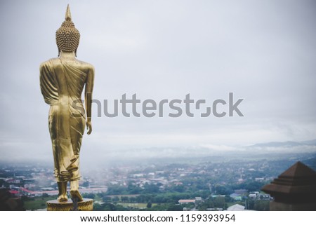 Rear image of the buddha standing on the mountains as a beautiful background in the morning.Wat Phra That Khao Noi, Nan Province, Thailand.