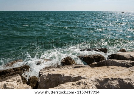 Small ocean sea waves on stone beach. Background wallpaper picture with roaring waves.