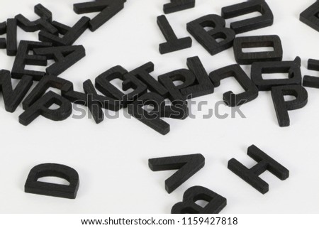 a heap of black wooden letters are lying in the studio